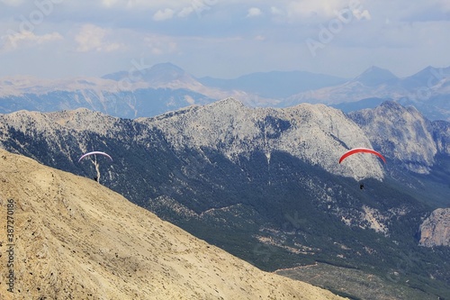 Paragliders flying above Tahtali Mountain in Kemer, Antalya Region, Turkey with Taurus Mountains in background