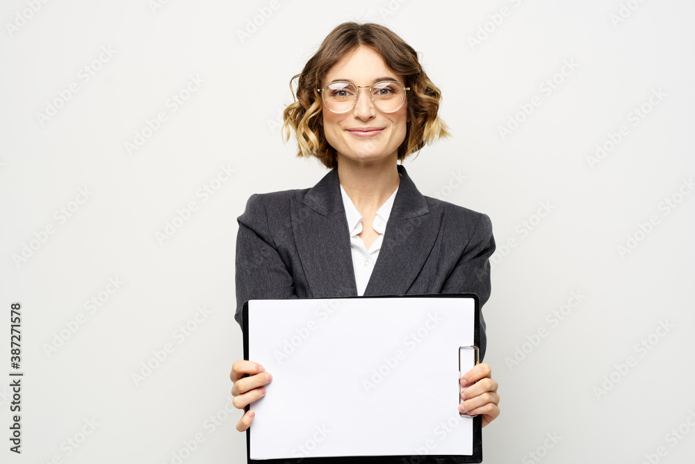 Business woman with a folder of documents on a light background cropped view and shirt suit Business woman with a folder of documents on a light background cropped view and shirt suit