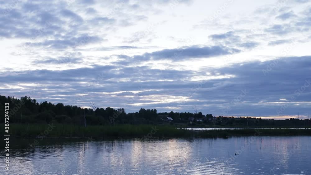 First person view with blurred background. Sailing on a wooden fishing boat on the lake after sunset. Dried flooded trees and branches on the pond. First person view with blurred background. Sailing on a wooden fishing boat on the lake after sunset. Dried flooded trees and branches on the pond.
