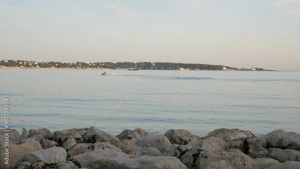 Jet ski in front of Antibes Cape on the Mediterranean sea on a winter afternoon Jet ski in front of Antibes Cape on the Mediterranean sea on a winter afternoon