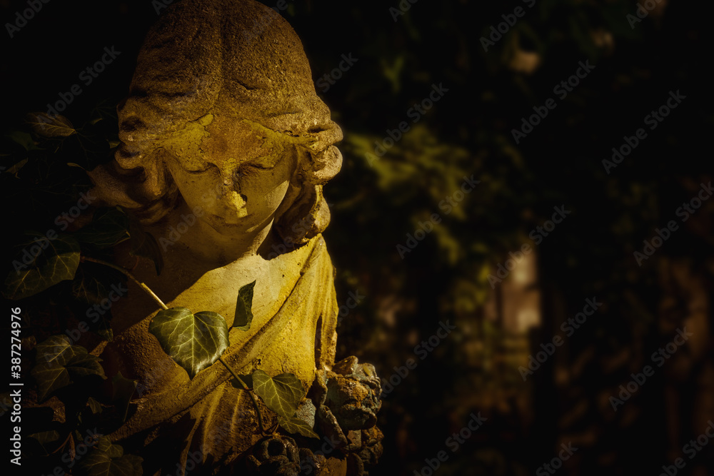 Sad winged angel as symbol of pain and death.. Close up an ancient statue. Copy space for design. Sad winged angel as symbol of pain and death.. Close up an ancient statue. Copy space for design.