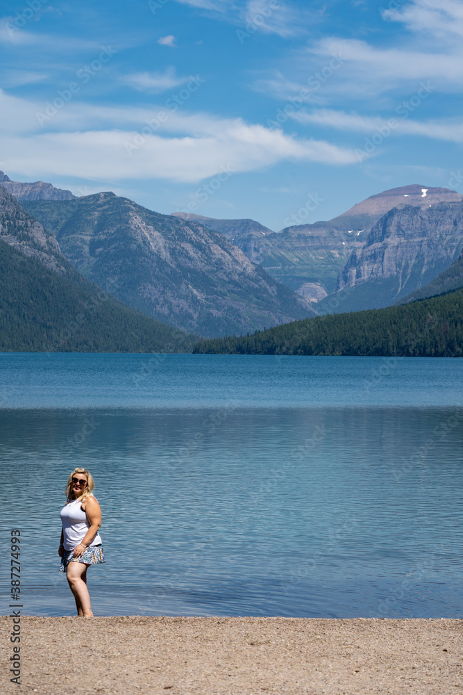 Attractive young woman poses at the scenery of Bowman Lake in Glacier National Park Montana