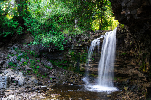 A waterfall flows freely into the river below  at Hilton Falls Conservation Area in Ontario.