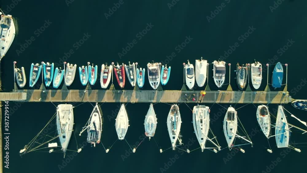 Top View Of People Walking On A Concrete Pier With Docking Boats In Gdynia, Poland - Aerial Drone Shot Top View Of People Walking On A Concrete Pier With Docking Boats In Gdynia, Poland - Aerial Drone Shot