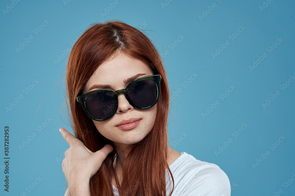 Woman wearing sunglasses long hair lipstick close-up blue background Woman wearing sunglasses long hair lipstick close-up blue background