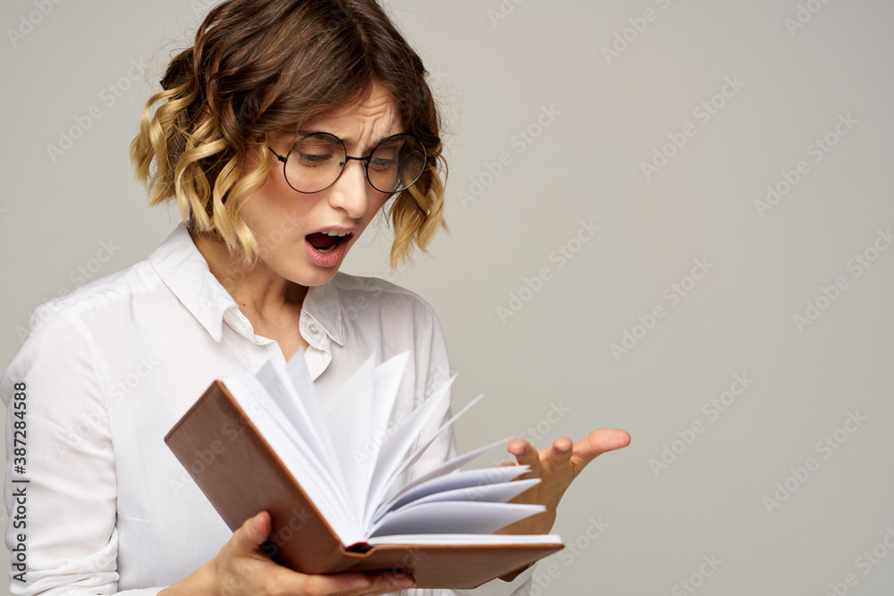 woman with notepad in hands business work beige background glasses hairstyle