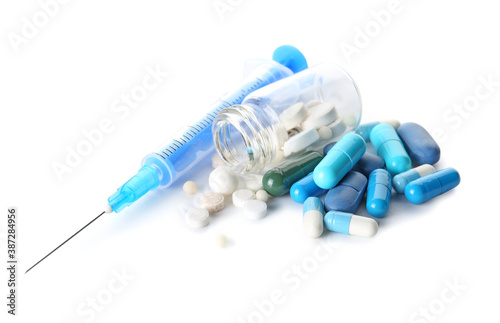 Pills and syringe for injection on white background