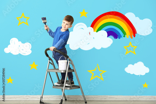 Cute little boy painting ra...