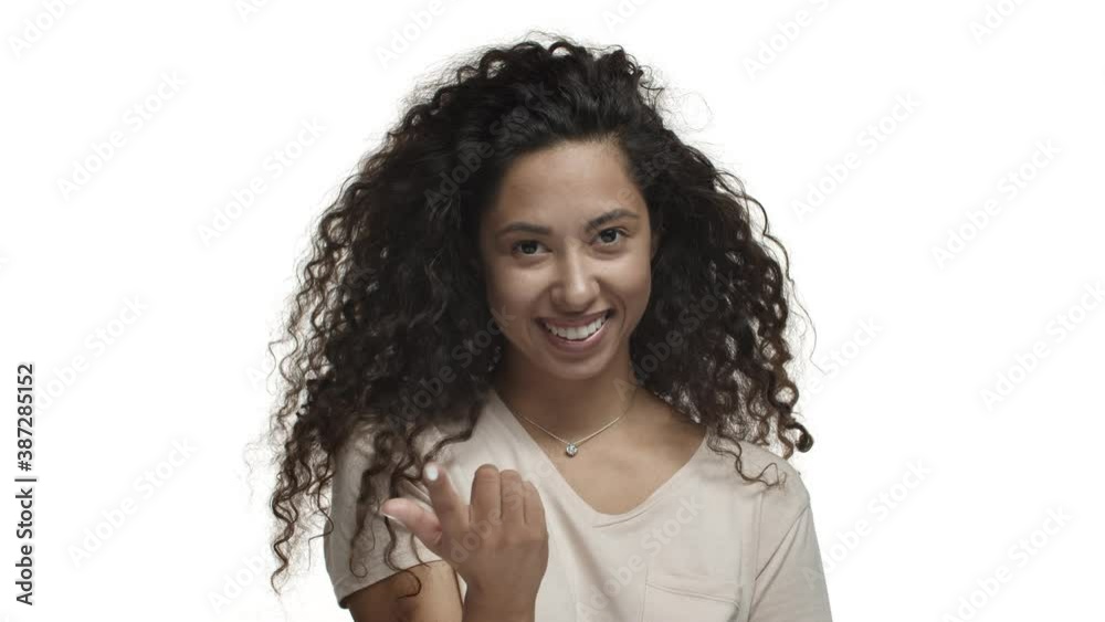 Close-up of flirty dark-skinned woman with long curly hair, flicking finger to invite someone, asking to come closer and smiling coquettish, standing over white background Close-up of flirty dark-skinned woman with long curly hair, flicking finger to invite someone, asking to come closer and smiling coquettish, standing over white background