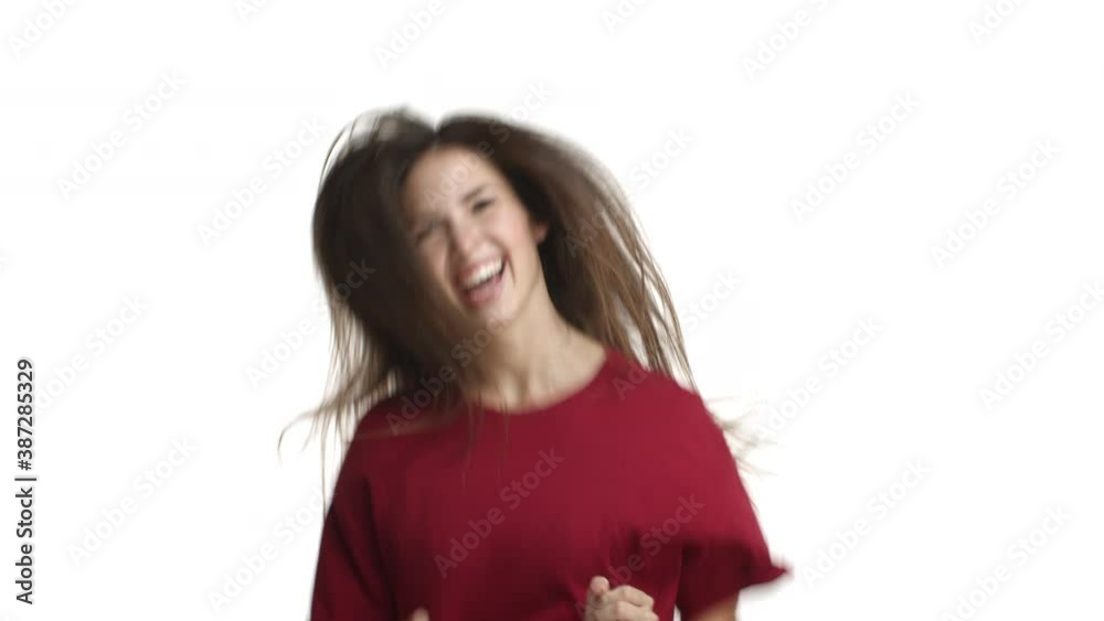 Video of beautiful happy woman in red t-shirt, rejoicing, jumping from happiness and smiling, standing over white background Video of beautiful happy woman in red t-shirt, rejoicing, jumping from happiness and smiling, standing over white background