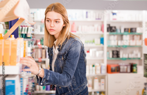 Attentive young girl chooses medicine in a pharmacy