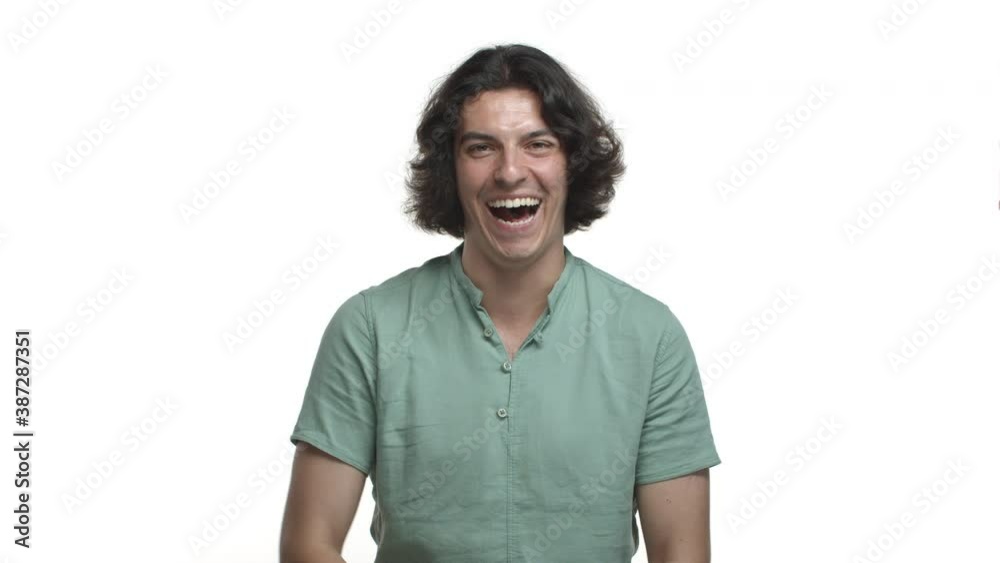 Handsome hispanic guy with long dark hair, wearing green casual shirt, laughing and smiling happy, standing over white background Handsome hispanic guy with long dark hair, wearing green casual shirt, laughing and smiling happy, standing over white background