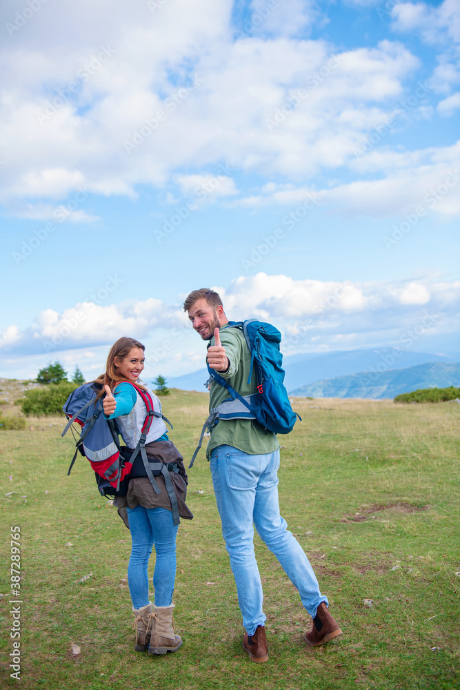 Happy couple hiking and enjoying a valley view Happy couple hiking and enjoying a valley view