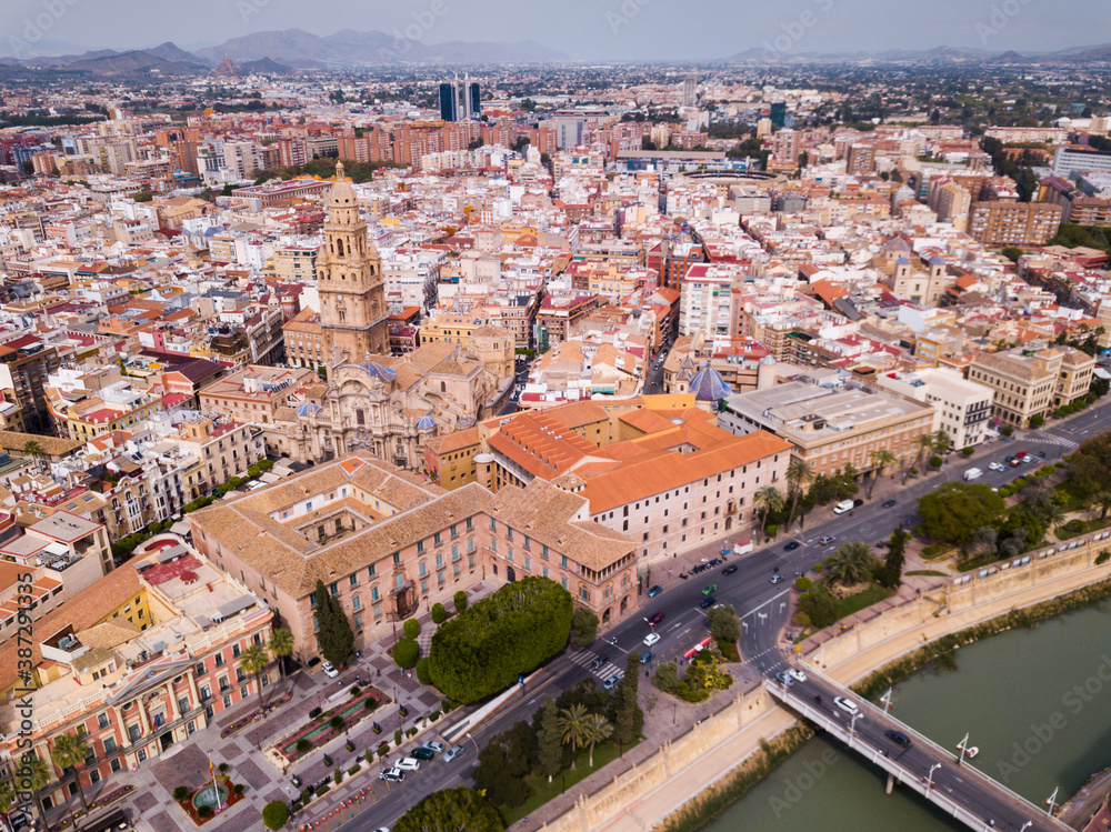 View from drone of residential areas and catholic cathedral belfry of Spanish town of Murcia on Segura river