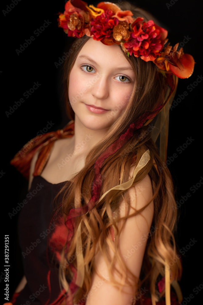 Naklejka premium Closeup of young girl with green eyes, flower crown and red dress