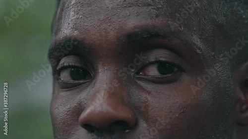 Portrait of athletic perspiring guy resting after powerful workout training, African American bodybuilder man looking to camera