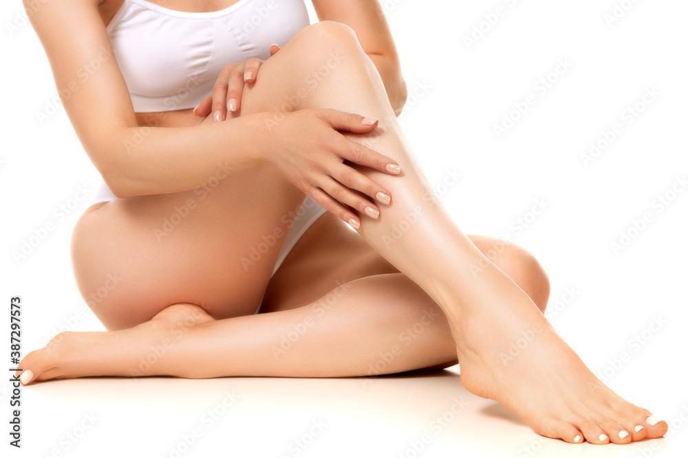 Wellness and beauty concept, beautiful slim woman in white underwear sitting on white floor. Wellness and beauty concept, beautiful slim woman in white underwear sitting on white floor.