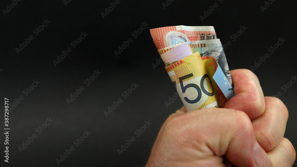 Φωτογραφία A close up of a wad of cash money notes in a tightly clenhed fist