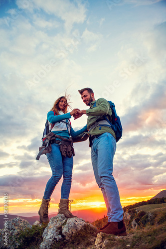 Couple on Top of a Mountain Shaking Raised Hands