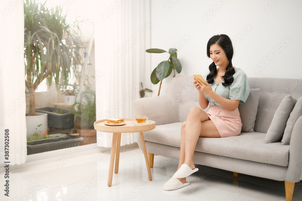 Young woman is chat on a smartphone at a sofa. Young woman is chat on a smartphone at a sofa.