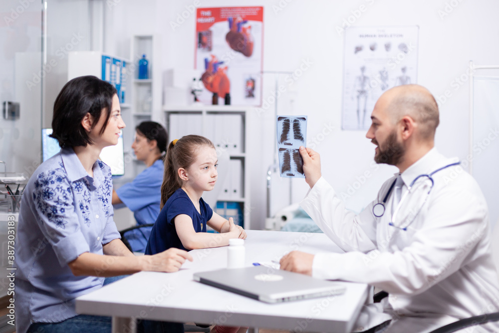 Pediatrician explaining diagnosis to mother and child holding radiography in hospital office. Healthcare physician specialist in medicine providing health care services treatment examination. Pediatrician explaining diagnosis to mother and child holding radiography in hospital office. Healthcare physician specialist in medicine providing health care services treatment examination.