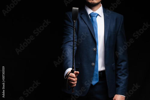 Photos male dominant holds a leather whip Flogger for hard BDSM sex
