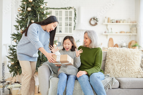 Little girl happy with present giving by her elder sister on Christmas Day photo