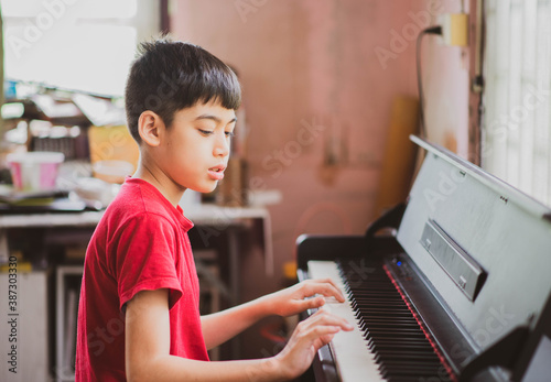 Little boy learning practicing piano online digital tablet