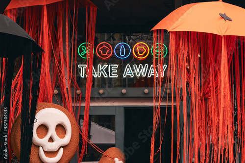 Scary Halloween decorations. Gingerbread man with drawn skull, bones and pumpkins at farm market. Kids trick or treat. Take away neon singn cafe autumn fall decor photo