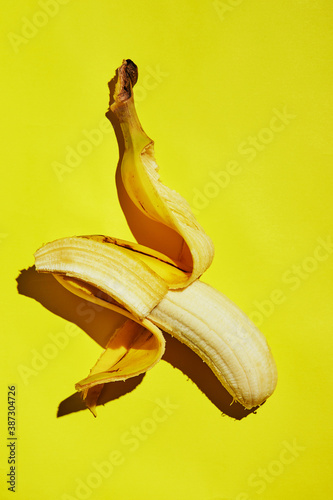 Half peeled banana isolated on yellow gradient background