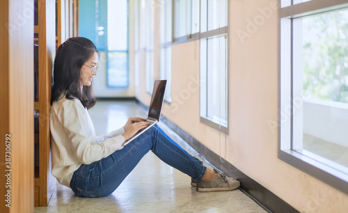 Back to school education knowledge college university concept. Female student study in library using laptop and searching internet  © sutthinon602