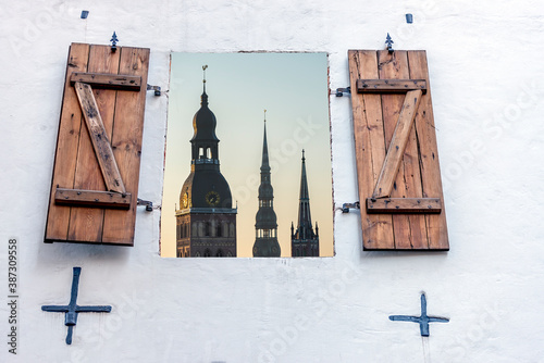 Medieval churches seen through window of old European building, Baltic region...