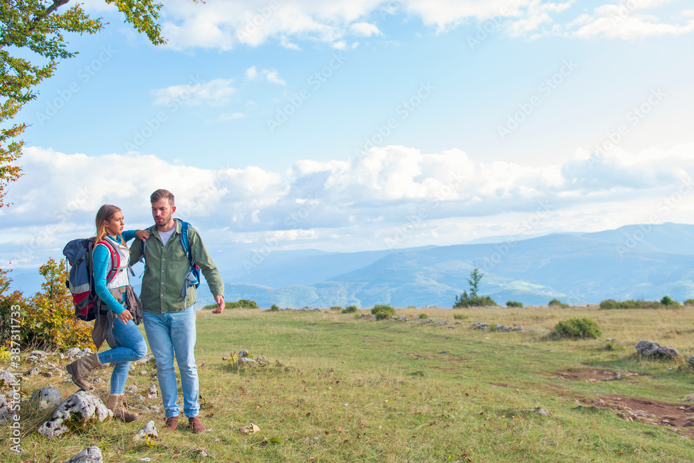 Happy couple hiking and enjoying a valley view