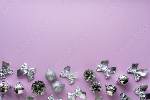 Christmas or new year composition with various silver decorations on a lilac background. Space for text