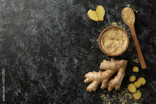 Fotografie Ginger and bowl with ginger powder on black smoky background