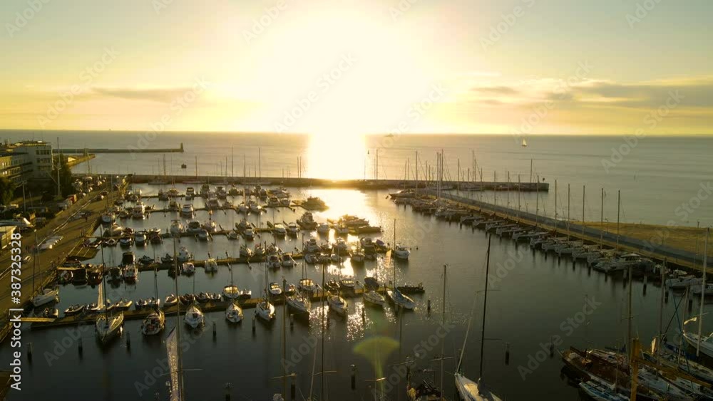 Marina Gdynia With Sailboats And Yachts Floating At The Serene Waters Of Baltic Sea During A Golden Sunset In The Background In Gdynia, Poland. - aerial drone shot Marina Gdynia With Sailboats And Yachts Floating At The Serene Waters Of Baltic Sea During A Golden Sunset In The Background In Gdynia, Poland. - aerial drone shot