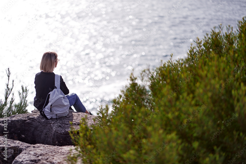 Tourism concept. Young traveling woman with rucksack enjoying ocean view. Tourism concept. Young traveling woman with rucksack enjoying ocean view.