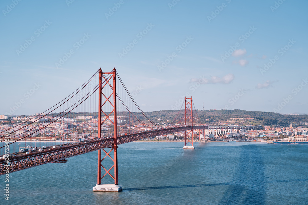 Naklejka premium Beautiful landscape with suspension 25 April bridge bridge over the Tagus river in Lisbon, Portugal.