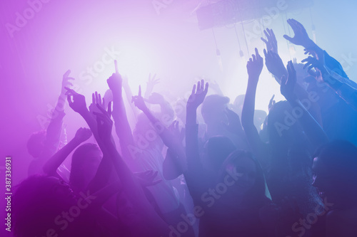 Photo of big company many people funny raise arms dance floor neon bright pink spotlight modern club indoors