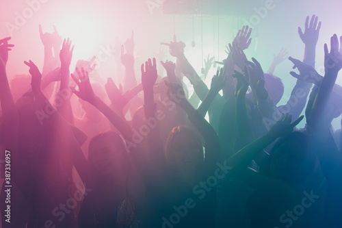 Photo of big company many people crazy atmosphere dance floor neon bright spotlight modern club indoors