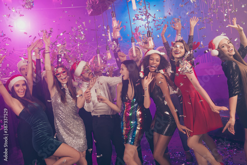 Photo of many crazy people cute lady hold wineglass dance falling confetti wear stylish outfit modern club indoors