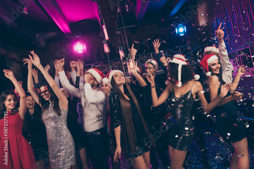 Photo of crazy funky people x-mas meeting fallig confetti rejoice raise hands dance floor modern club indoors