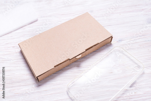 Brown flat cardboard box for cellphone, smartphone case packaging.