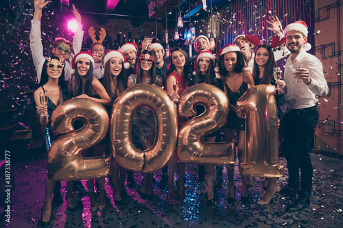 Photo portrait of celebrating group with champagne glasses 2021 golden balloons goofy santa claus deer headwear