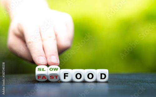 Hand turns dice and changes the expression "fast food" to "slow food".