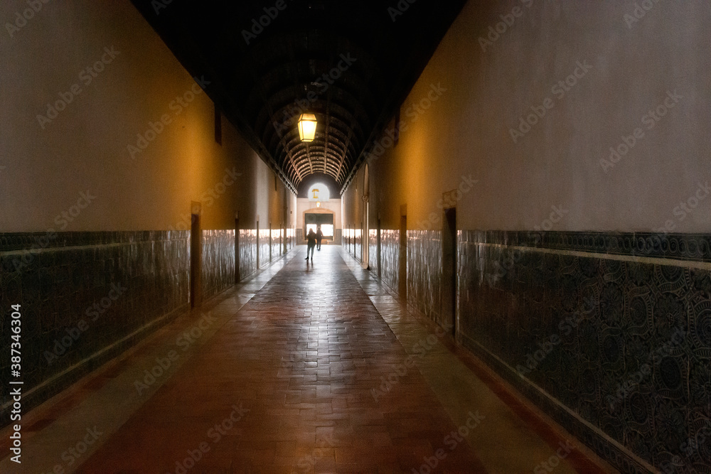Light At The End Of A Dark Hallway, With Two Distant Figures. Tomar, Portugal.