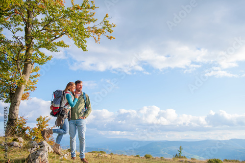 Happy couple hiking and enjoying a valley view