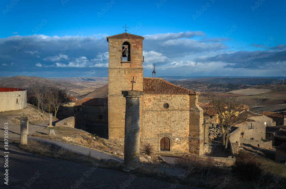 The Holy Trinity church with its bell tower on a blue day with clouds, Atienza, Guadalajara, Spain