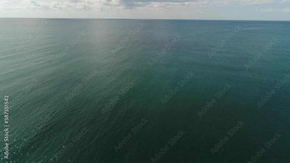 Aerial: epic panorama of the cold sea, gray sky with large clouds. Marine background