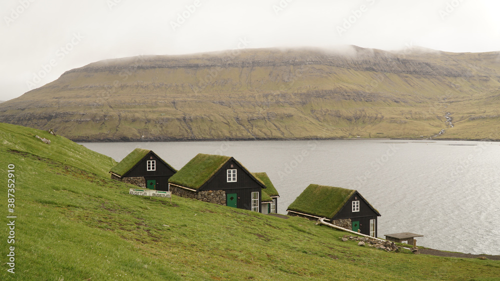 Views on Drangarnir Sea Stack and Tindhólmur Island on a cloudy day from the mountains at Bøur Village on the Faroe Islands in Denmark.